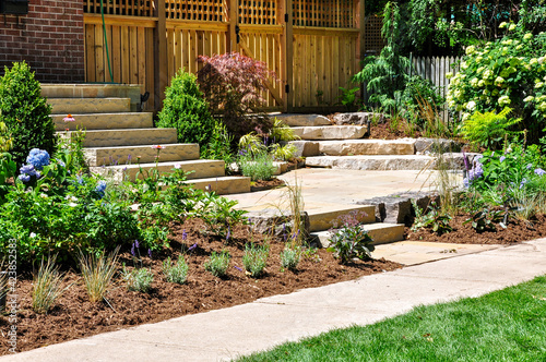 Huge natural stone slab flagstone steps create beautiful landscaping and a transition to a hidden garden in this front yard no grass urban garden.