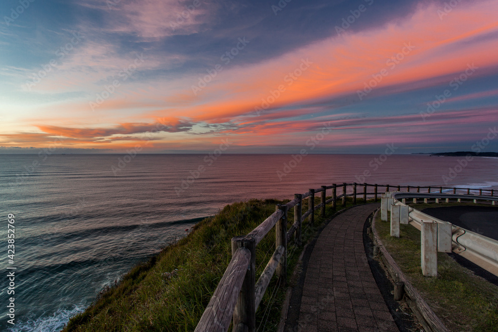 view down a road by the ocean at sunrise view down a road by the ocean at sunrise