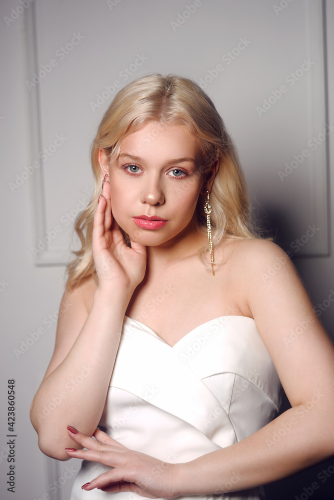 Beautiful bride portrait. A woman in a wedding dress with makeup and hairstyle in beautiful silver earrings. Wedding concept, beauty salon, wedding dress salon. Pensive girl. Beautiful bride portrait. A woman in a wedding dress with makeup and hairstyle in beautiful silver earrings. Wedding concept, beauty salon, wedding dress salon. Pensive girl.