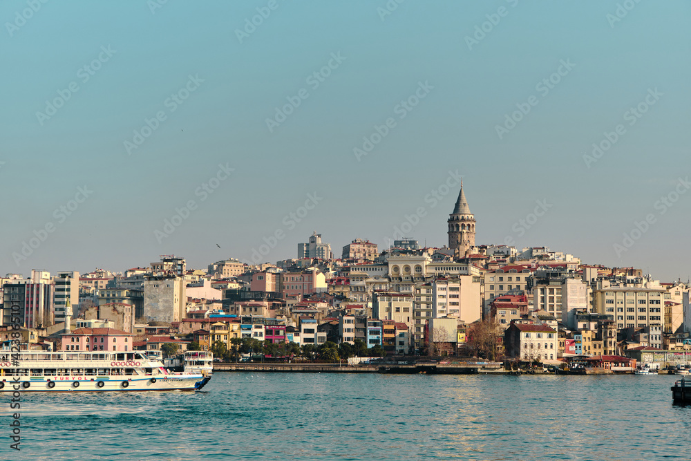 Old and ancient galata tower in istanbul made by genoese sailor and istanbul bosphorus with passenger ferry and ship and galata bridge during sunny day. 03.03.2021. istanbul Turkey