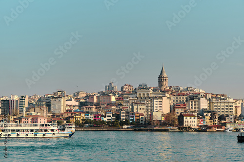 Old and ancient galata tower in istanbul made by genoese sailor and istanbul bosphorus with passenger ferry and ship and galata bridge during sunny day. 03.03.2021. istanbul Turkey © SKahraman