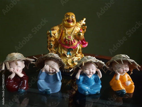 Laughing Buddha and little monks photo
