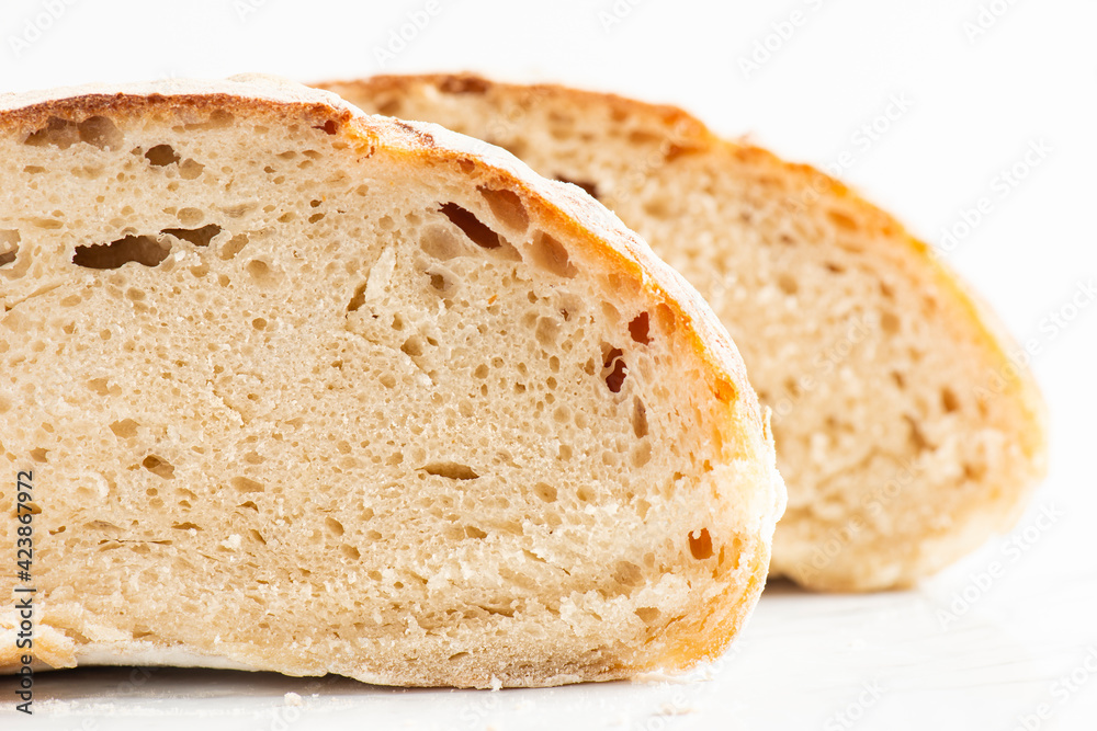 Detailed closeup of baked sourdough artisan bread with a rustic crust and high water hydration.