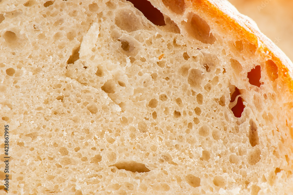 Detailed closeup of baked sourdough artisan bread with a rustic crust and high water hydration.