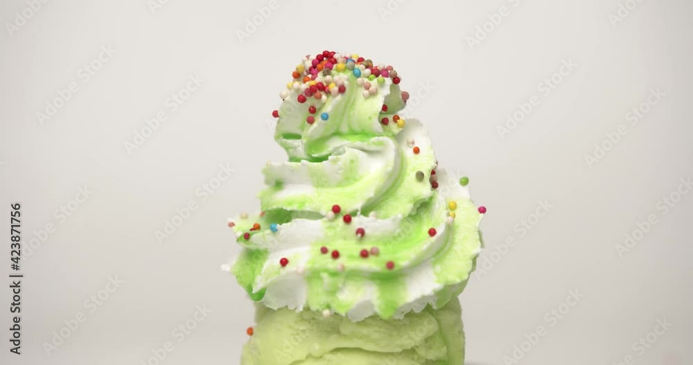 Pour Sweet candy full many colors drop whipped cream on green background, Food concept Front view.