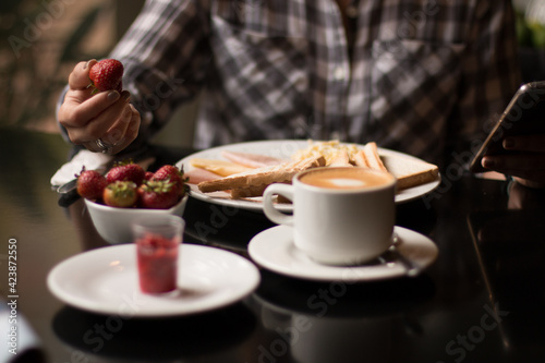 Table with breakfast in restaurant with fresh strawberries  coffee  toast
