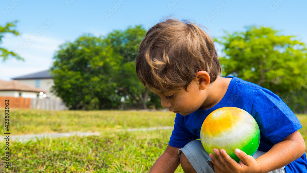 Fototapeta premium Boy and his ball in the park