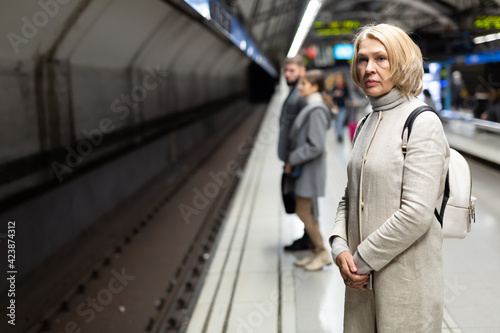 Wallpaper Mural Portrait of modern middle aged woman waiting for train on subway platform .. Torontodigital.ca