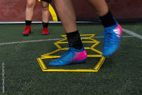 Football players on a hexagonal speed and agility training ladder rings in the field photo