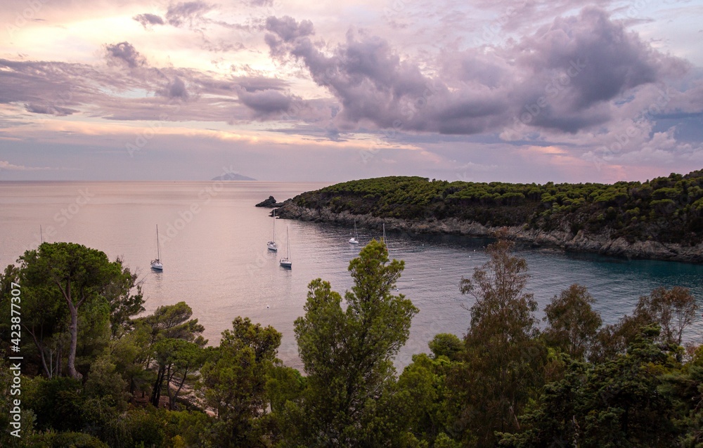 sailboats on the water during dramatic sunset at bay of Fetovaia, Island of Elba, Tuscany, Italy