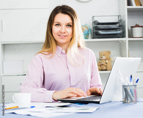 Smiling female manager working effectively on project in office