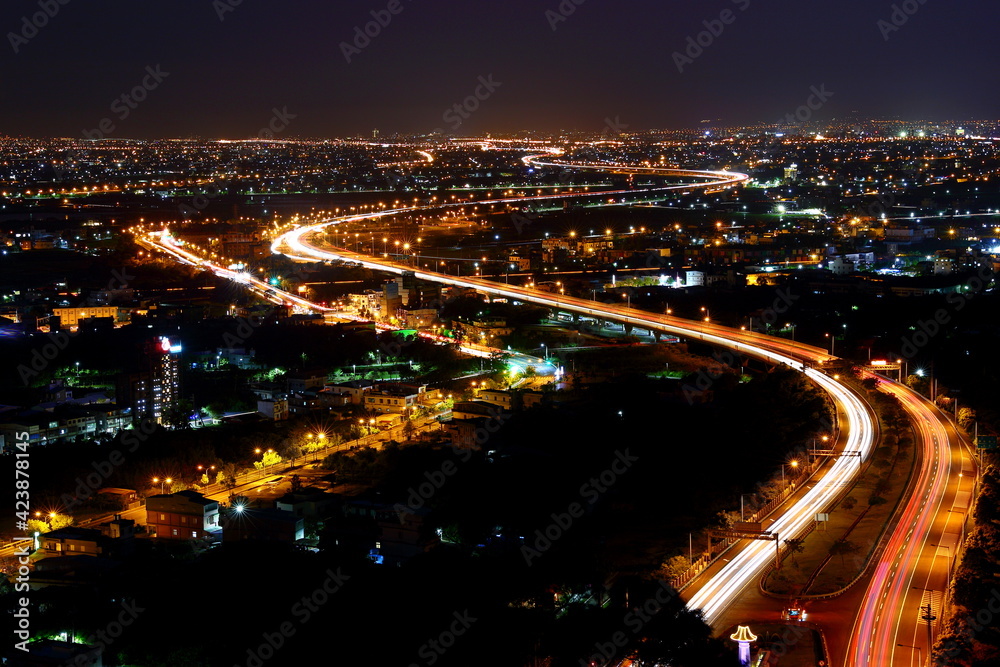 Night aerial view of the Lanyang Plain, with car light trails at night in Yilan, Taiwan.