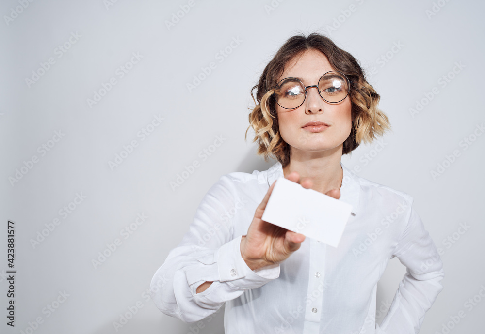 Business woman with a business card on a light background work advertisement