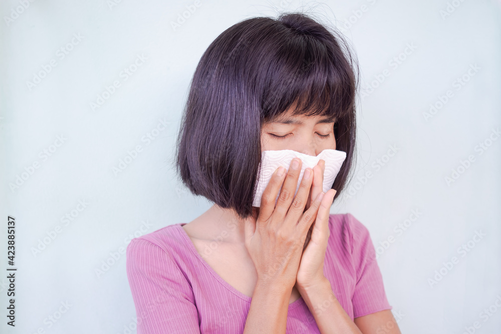 Asian woman have a cold. she is sneezing into handkerchief. sick from virus problem. authentic black hair, skin tan and slim shape. health care concept. Asian woman have a cold. she is sneezing into handkerchief. sick from virus problem. authentic black hair, skin tan and slim shape. health care concept.