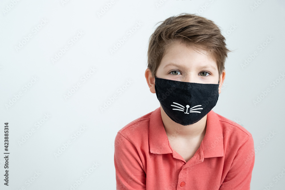 Portrait little smiling caucasian boy in a funny medical mask. Protection against coronavirus in a pandemic. Emotions of a child. Portrait little smiling caucasian boy in a funny medical mask. Protection against coronavirus in a pandemic. Emotions of a child.