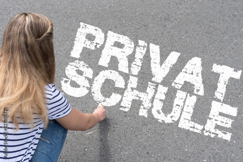 Eine junge Frau schreibt das Wort Privatschule  photo