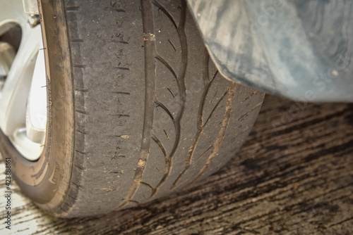 Old tire with worn tread and scratch, worn old car tire tread with damaged, scratch, worn tire tread in the car wheel