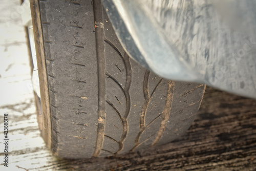 Old tire with worn tread and scratch, worn old car tire tread with damaged, scratch, worn tire tread in the car wheel