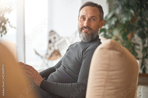 Happy adult caucasian man is working in a modern office