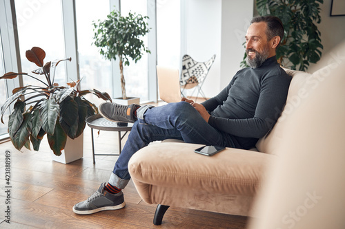 Happy adult caucasian man is working in a modern office