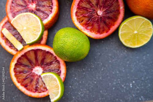 Blood Orange lime sliced and whole, on black background, close-up, copy space, template, postcard