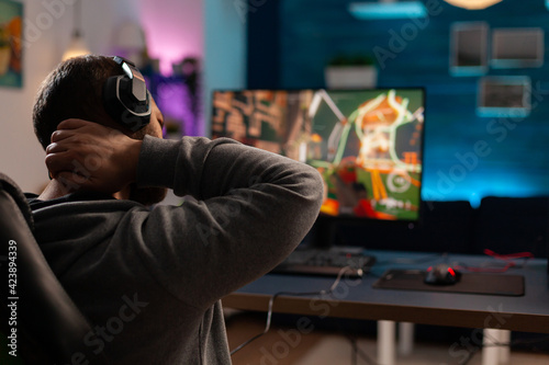 Competitive videogamer using powerful computer playing online videogame. Virtual streaming cyber streatching after performing gaming tournament using professional equipment.