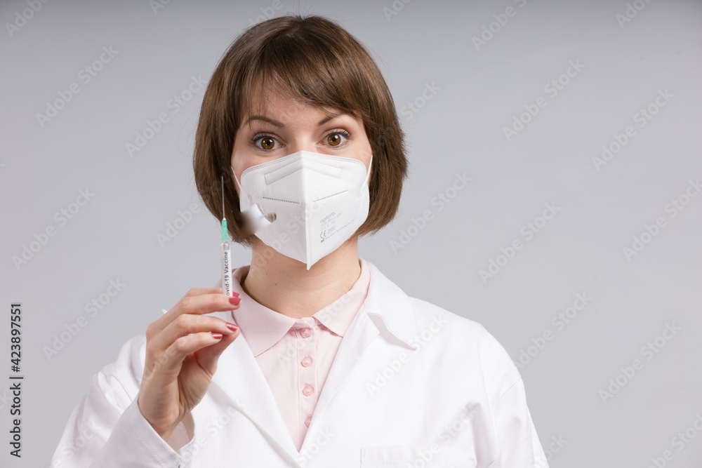 female doctor or nurse with syringe pulled up with a vaccination serum female doctor or nurse with syringe pulled up with a vaccination serum