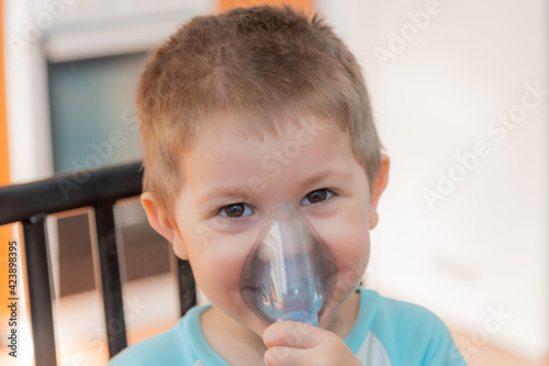 Foto Little boy using nebulizer during inhaling therapy