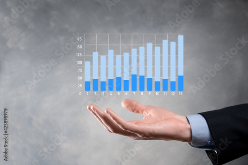 Businessman holding graph growth and increase of chart positive indicators in his business.Investment up concept.analyzing sales data and economic,strategy and planning, Digital marketing and stock 