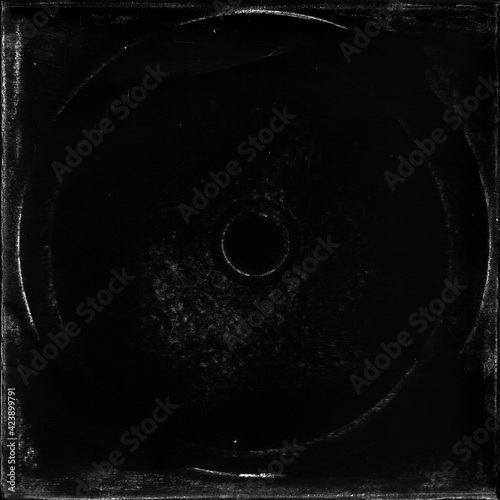 cd mark texture on paper for old cover art. grungy frame in black background. can be used to replicate the aged and worn look for your creative design.