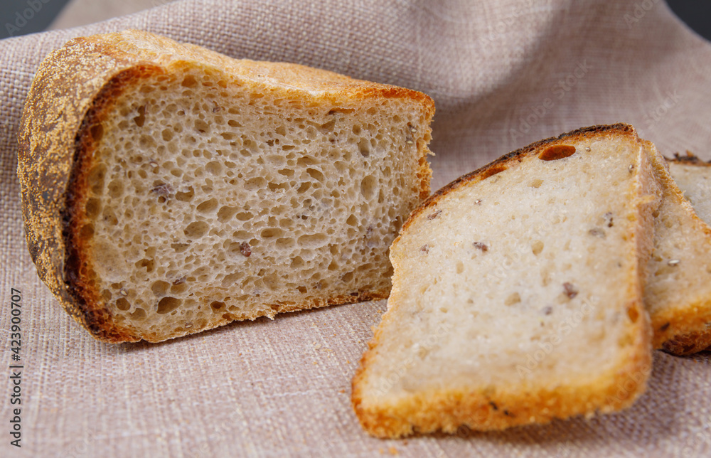 Loaf and slices of bread on a linen tablecloth. Sourdough bread.