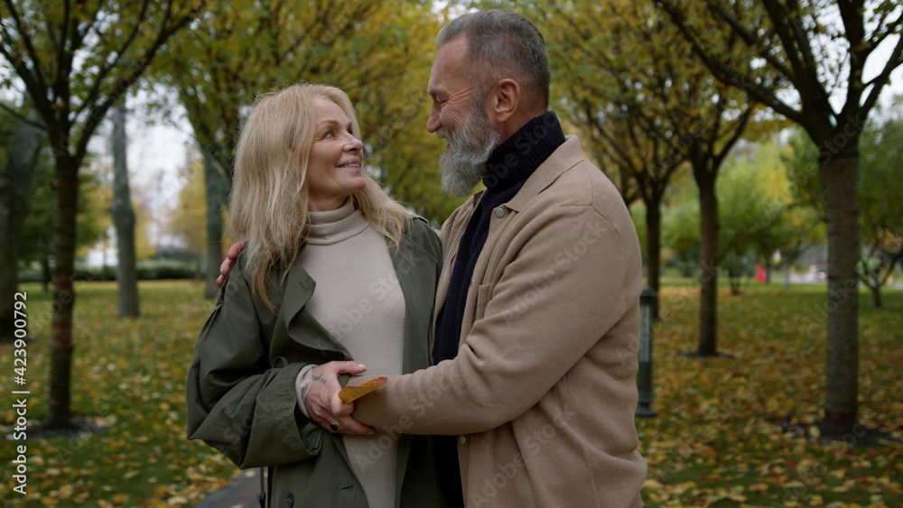 Close up romantic couple standing in autumn park in daytime. Happy lovers. Close up romantic couple standing in autumn park in daytime. Happy lovers.