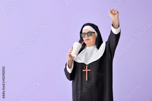 Funny senior nun with soda ...