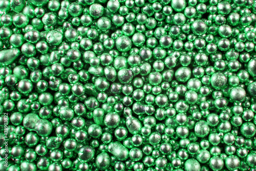 A background of many shiny green metal balls.