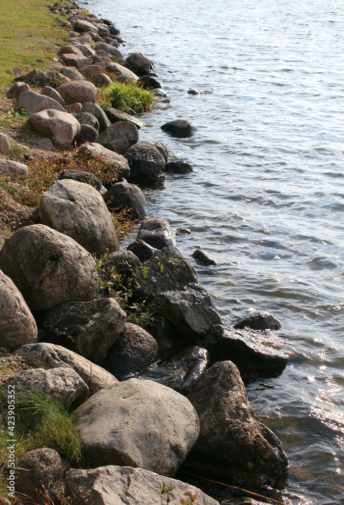 Northern stones near the shore of the reservoir. Natural background