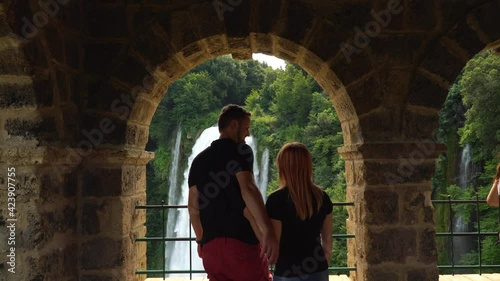Couple of man and woman look at water discharge, strong flow. The Cascata delle Marmore is a the largest man-made waterfall. Terni in Umbria Italy. Vacation concept. View point.
