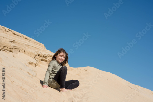 cute little girl playing in the sand dunes