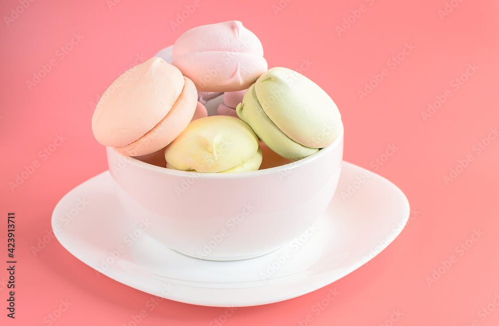 Homemade multicolored marshmallows on a white plate. Natural marshmallow isolated on a pink background. Copy space. Selective focus. Homemade multicolored marshmallows on a white plate. Natural marshmallow isolated on a pink background. Copy space. Selective focus.