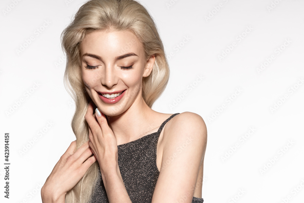 Smiling beautiful young blond woman on studio background with copy space, enjoying healthy moisturized skin, natural make up. Happy female model touching dyed hairs after coloring. Smiling beautiful young blond woman on studio background with copy space, enjoying healthy moisturized skin, natural make up. Happy female model touching dyed hairs after coloring.