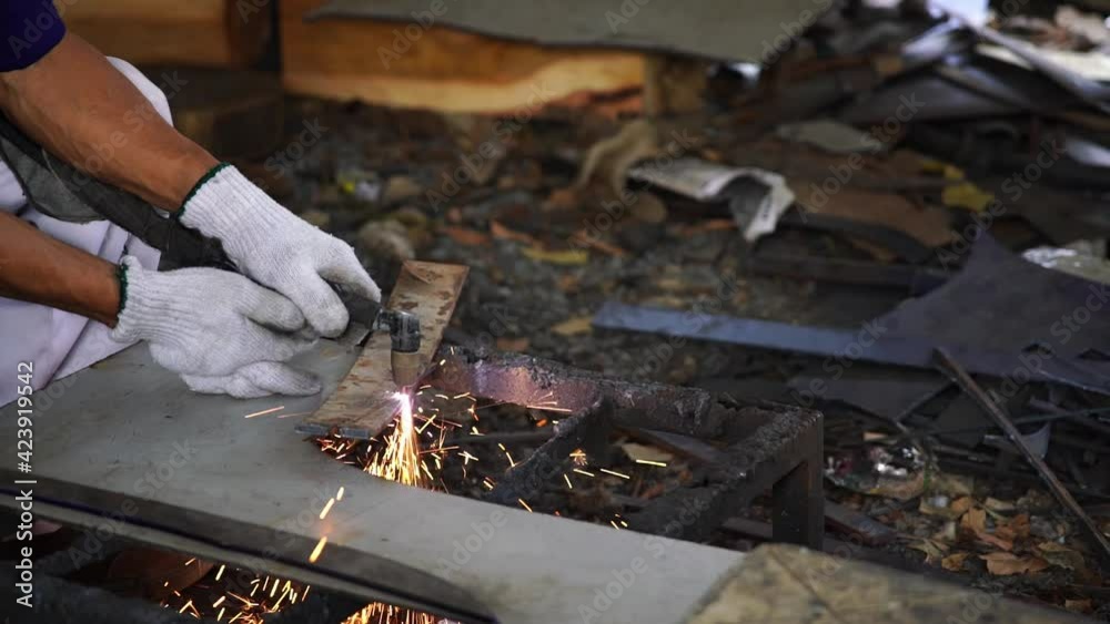 Workers are using gas to cut sheet metal or metal to achieve the desired profile in a small traditional factory. Workers are using gas to cut sheet metal or metal to achieve the desired profile in a small traditional factory.