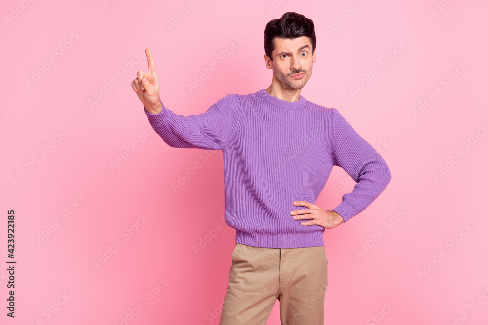 Photo of funny funky young man dressed purple pullover pointing finger empty space isolated pink color background Photo of funny funky young man dressed purple pullover pointing finger empty space isolated pink color background