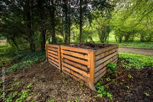 Φωτογραφία Two-part compost made of wooden slats filled with organic material situated in t