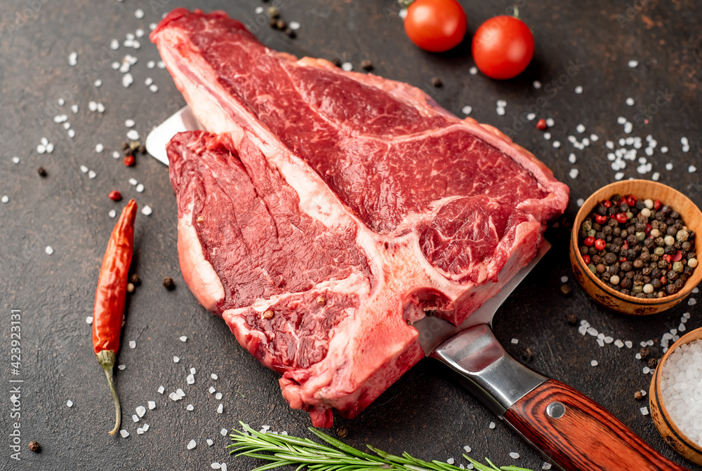 raw T-Bone Beef Steak on the knife on stone background