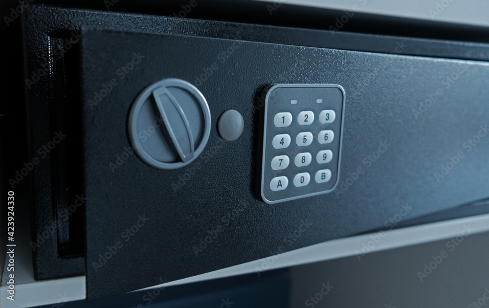 Metal safe box in the closet. Small narrow safe for keeping money or valuables in the hotel. Open safe door with buttons for entering a password. Compact strongbox inside cabinet. Empty safe. Metal safe box in the closet. Small narrow safe for keeping money or valuables in the hotel. Open safe door with buttons for entering a password. Compact strongbox inside cabinet. Empty safe.