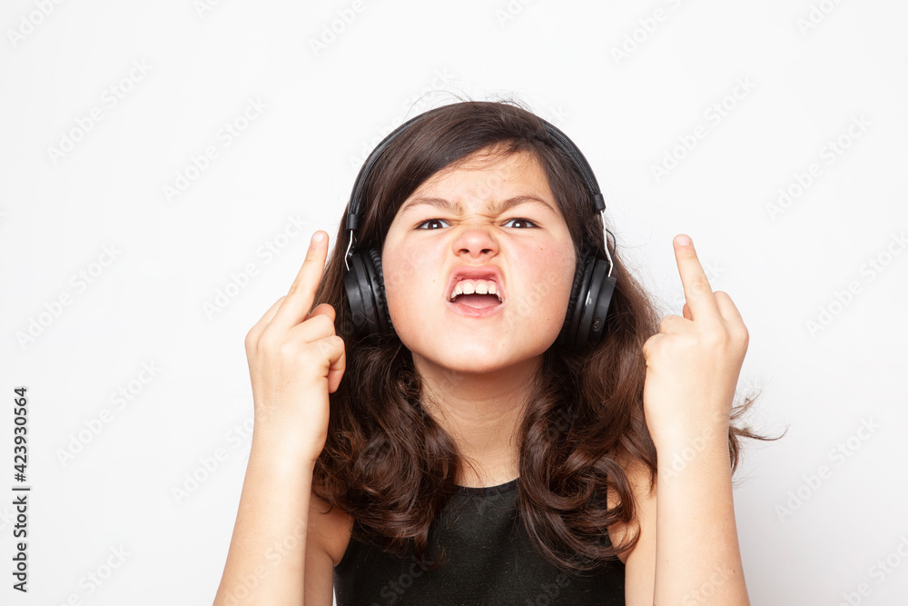 Emotional portrait of teen girl - isolated on white background. A furious teenager looking with anger at the camera and show a middle finger or fuck you sign. Emotional portrait of teen girl - isolated on white background. A furious teenager looking with anger at the camera and show a middle finger or fuck you sign.