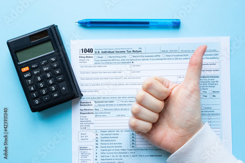 1040 individual tax form. Man showing hand thumbs up 