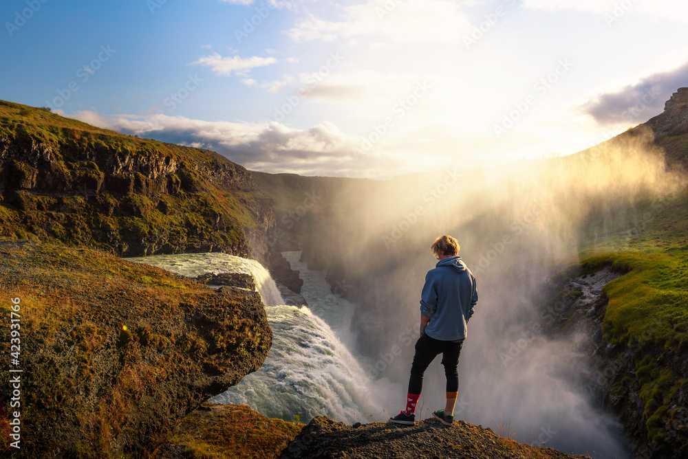 Obraz premium Young hiker standing at the edge of the Gullfoss waterfall in Iceland