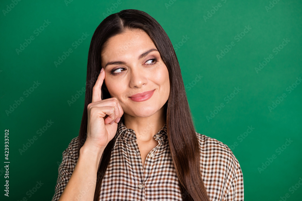 Photo of minded smart lady look empty space finger temple wear plaid shirt isolated green color background Photo of minded smart lady look empty space finger temple wear plaid shirt isolated green color background