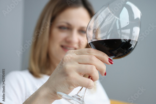 Woman holds glass of red wine in her hand