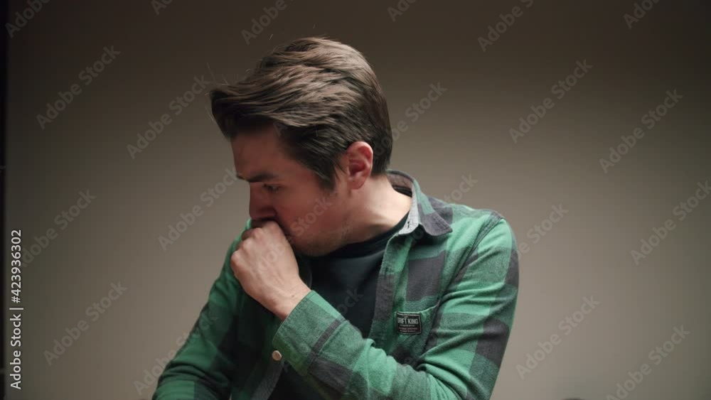 Young man with checkered shirt on gray background coughs. Slow-motion Young man with checkered shirt on gray background coughs. Slow-motion